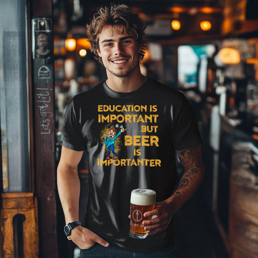 Man wearing a black tee shirt saying 'Education is important but beer is importanter' in cartoon style holding a beer in a bar setting.