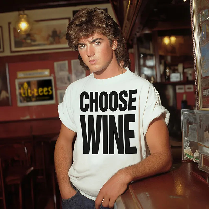 George Michael lookalike standing in a bar wearing a white T shirt with text saying 'Choose Wine'