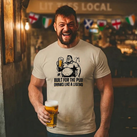 Man wearing a t-shirt with a graphic design and holding a beer in a pub setting.