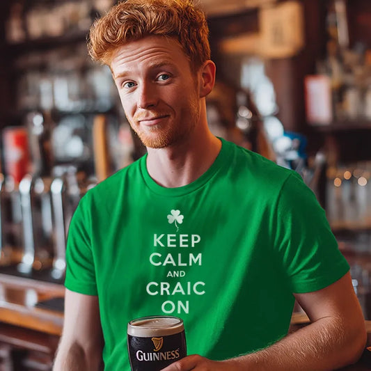 Man wearing a green t-shirt with 'Keep Calm and Craic On' holding a Guinness in a bar setting.
