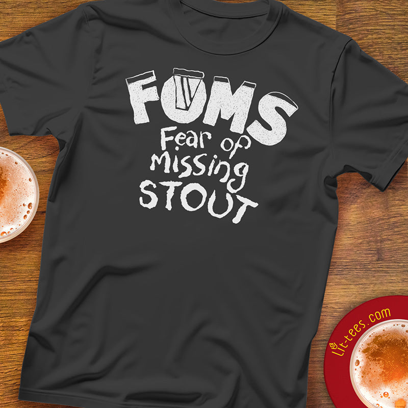 Black t-shirt with 'FOMS Fear of Missing Stout' text on a wooden pub table
