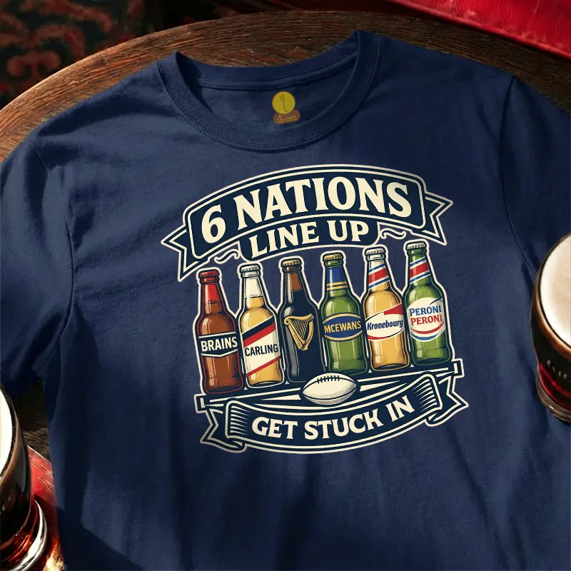 Navy blue t-shirt with '6 Nations Line Up Get Stuck In' graphic featuring beer bottles and a rugby ball on a wooden bar table.