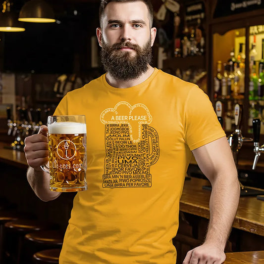 Man in a bar holding a beer and wearing a yellow t-shirt with a beer graphic  made up of the phrase '1 beer please' in multiple languages 