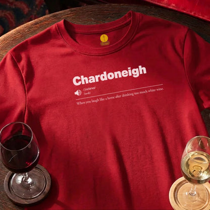 Red t-shirt with 'Chardoneigh' text and wine glasses on a wooden bar surface