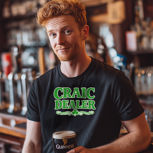 Man wearing a black t-shirt with 'Craic Dealer' holding a pint of Guinness in a bar setting