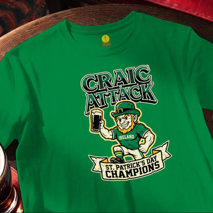 Green t-shirt with 'Craic Attack' and 'St. Patrick's Day Champions' design on a wooden bar table.
