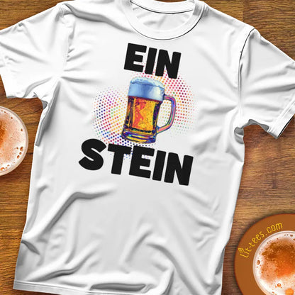 White t-shirt with 'Ein Stein' design featuring a colorful mug on a wooden surface.