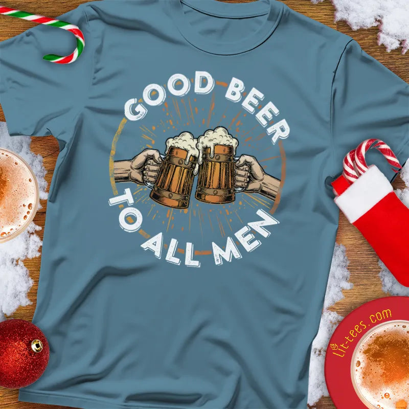 Blue t-shirt with 'Good Beer to All Men' graphic on a festive background with drinks and decorations.
