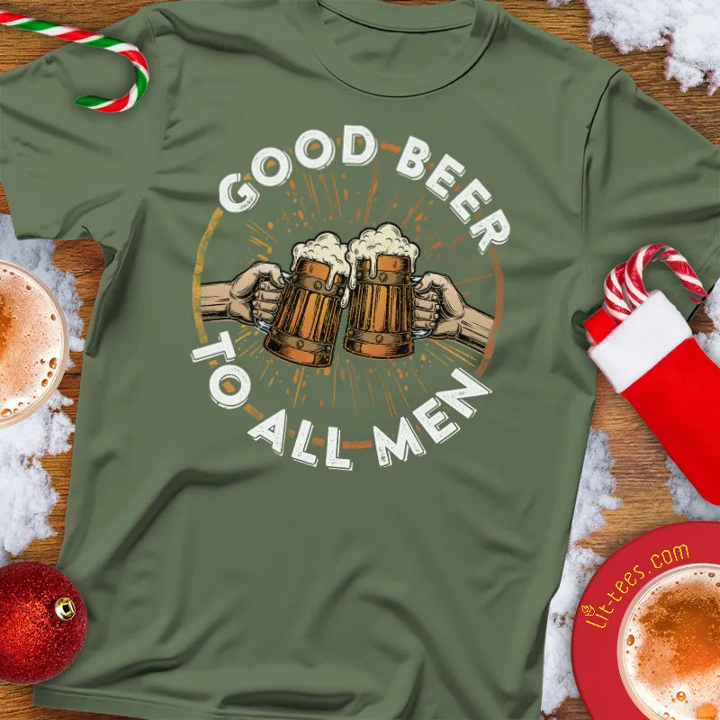 Green Christmas t-shirt with 'Good Beer to All Men' graphic on a festive background with Christmas decorations.