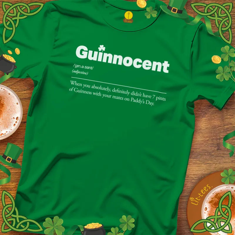Green t-shirt with 'Guinnocent' text on a wooden surface with St. Patrick's Day decorations.
