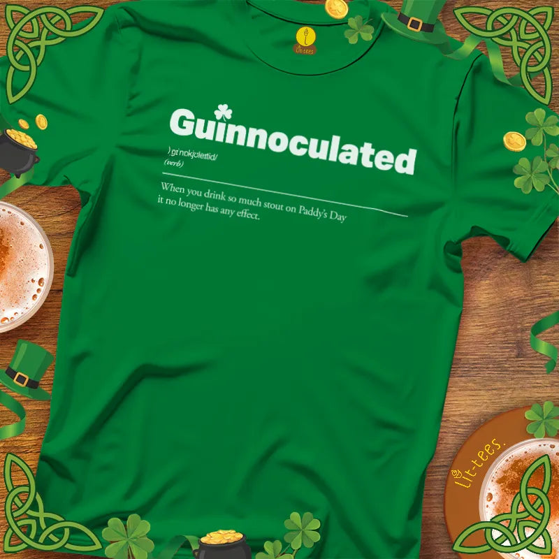 Green t-shirt with 'Guinnoculated' text on a wooden surface with St. Patrick's Day decorations.