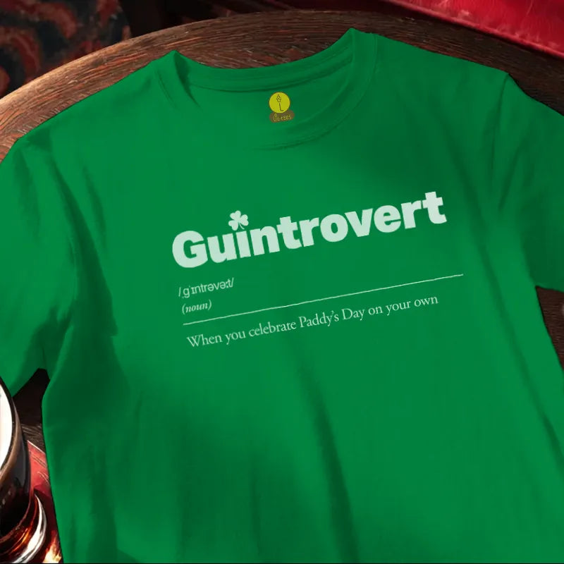 Green t-shirt with 'Guintrovert' text on a wooden bar table with beer glass