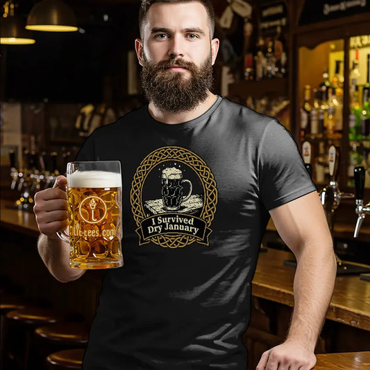 Man holding a pint of beer standing in a bar wearing a blue t shirt with text saying 'I survived Dry January'
