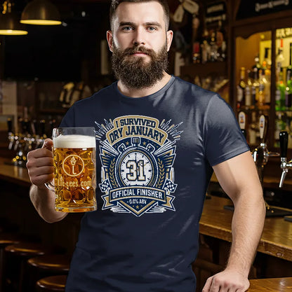 Man holding a pint of beer standing in a bar wearing a blue t shirt with text saying 'I survived Dry January'