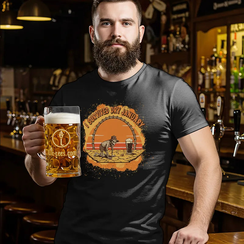 Man holding a pint of beer standing in a bar wearing a black t shirt with text saying 'I survived Dry January'