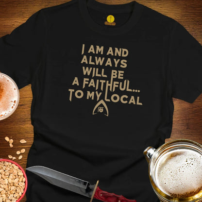 A black graphic t-shirt laid flat on a wooden surface, featuring the text 'STAY FAITHFUL.
