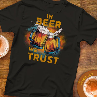 Black t-shirt with 'In Beer We Trust' graphic on a wooden surface with beer glasses.