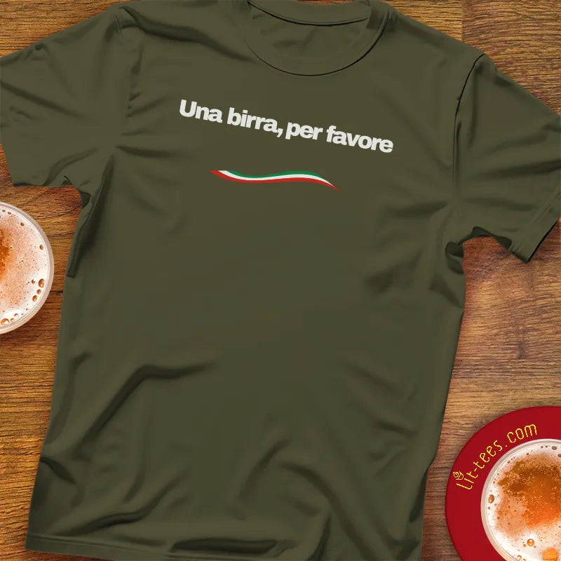 Green t-shirt with text saying 1 beer please in Italian on a wooden table with pints