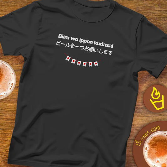 Black t-shirt with Japanese text saying 1 beer please and flag design on a pub table with drinks.