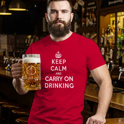 Man in bar wearing a red t-shirt holding a beer with a humorous message saying 'Keep Calm and Carry On Drinking' 