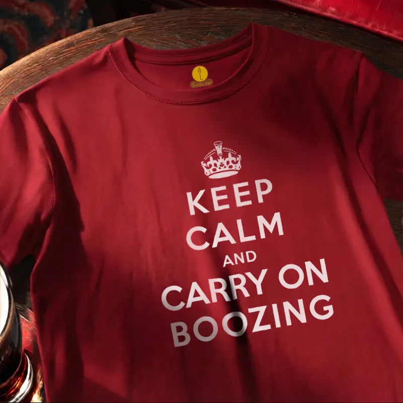 Red T Shirt on round bar table with humourous text saying Keep Calm and Carry on Boozing