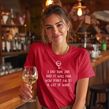 Woman in a red t-shirt with a humorous Dry January text design, holding a glass of wine in a bar setting.