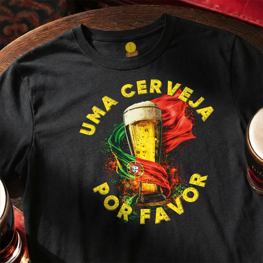Black t-shirt with a beer graphic and text on a wooden surface. Uma cerveja, por favor - Portuguese