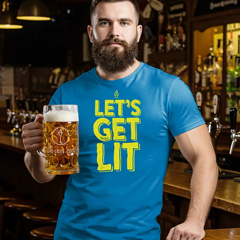 Man in bar holding a beer wearing a blue t shirt with text 'Let's Get Lit' 