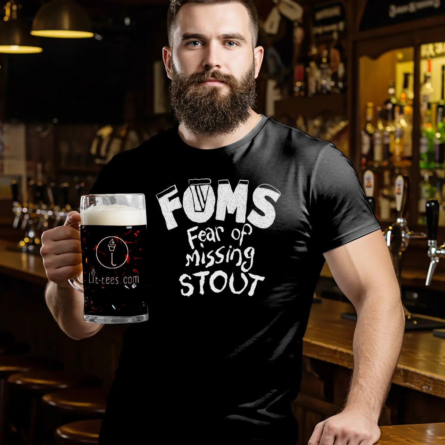 Man holding a Guinness wearing a black t-shirt with 'FOMS Fear of Missing Stout' text in a bar setting.