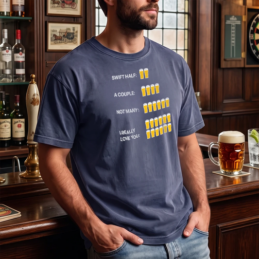 A man wearing a navy blue graphic t-shirt in a pub setting. The shirt features a humorous beer count graphic with text reading 'SWIFT HALF: A COUPLE: NOT MANY: I REALLY LOVE YOU:' next to corresponding numbers of beer glasses.