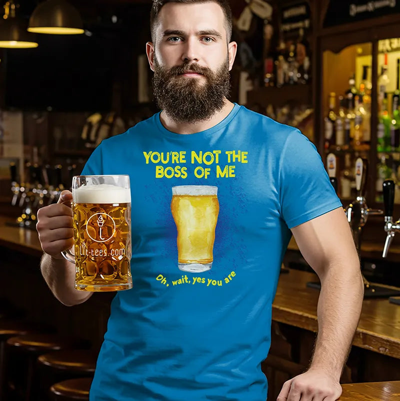 Man in a bar holding a beer glass wearing a blue t-shirt with a beer graphic and text, saying 'You're not the boss of me...oh wait yes you are'