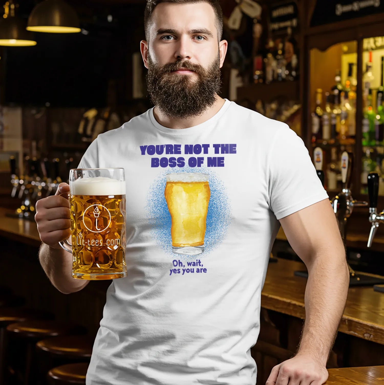 Man holding a beer mug in a bar wearing a t-shirt saying 'You're not the boss of me' with a graphic and text. 