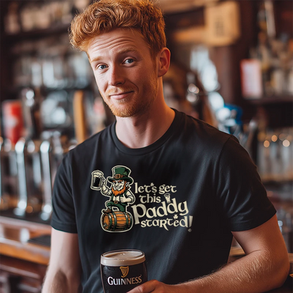 Man wearing a black t-shirt with a humorous design and text saying 'Let's Get This Paddy Started' holding a Guinness in a bar setting.