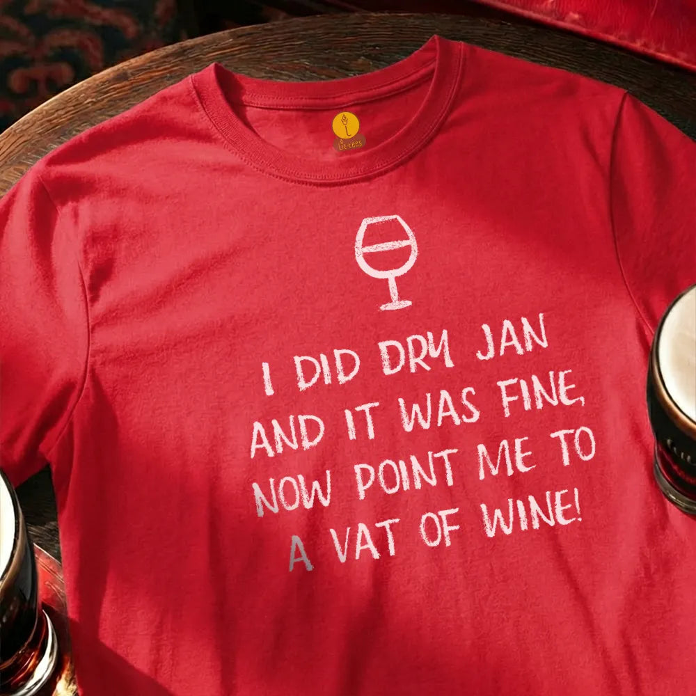 Red t-shirt with humorous text and wine glass graphic on a wooden bar table with glasses. 