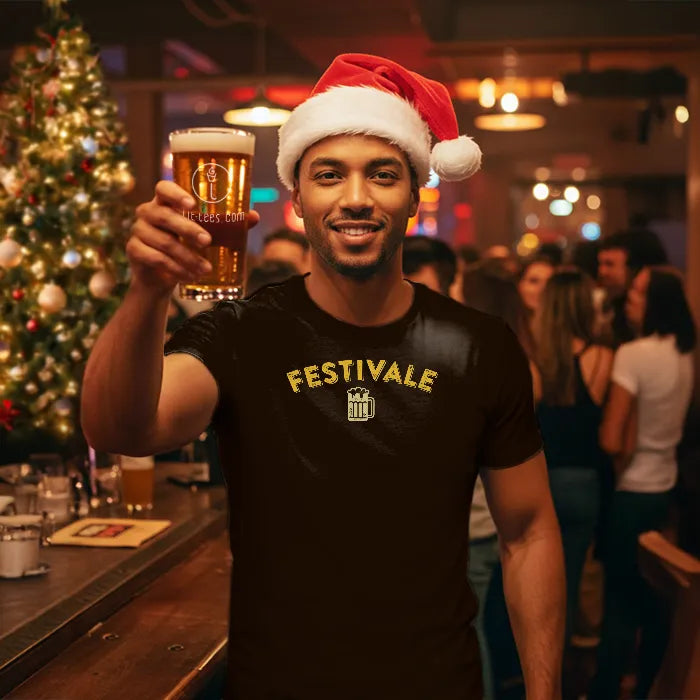 Man in a black Christmas themed 'Festivale' t-shirt and Santa hat holding a beer in a festive bar setting. Glass has lit-tees.com printed on it.
