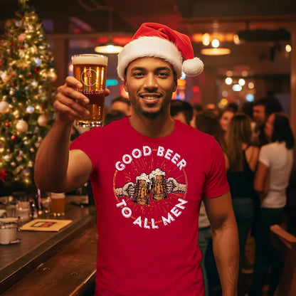 Man wearing a Santa hat and red 'Good Beer to All Men' shirt, holding a beer in a festive bar setting.