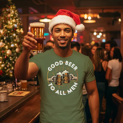 Man in a bar wearing a Santa hat and a t-shirt with 'Good Beer to All Men' text, holding a beer.