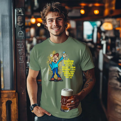 Young man holding a beer in a bar wearing a green tee shirt with a graphic character and humorous text saying 'If drinking alcohol affects short term memory just imagine what drinking alcohol can do' 