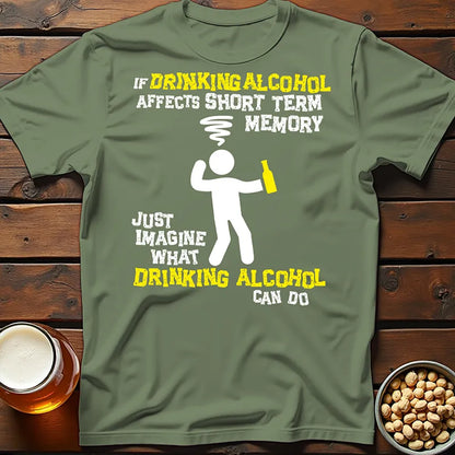 Green tee shirt with a graphic character and humorous text saying 'If drinking alcohol affects short term memory just imagine what drinking alcohol can do' on wooden surface with beer glasses.