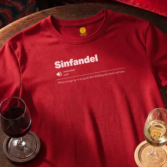 Red t-shirt with 'Sinfandel' text and wine glasses on a wooden bar table