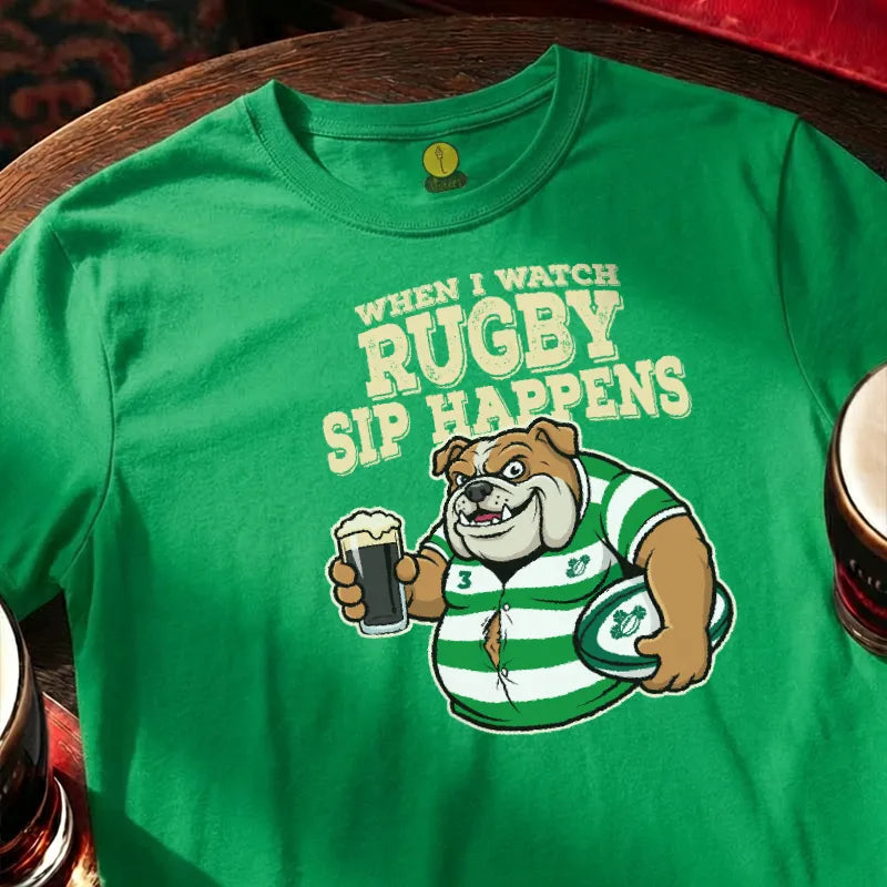 Green t-shirt with rugby-themed graphic and text  saying 'When I watch Rugby, Sip happens' on a wooden bar table