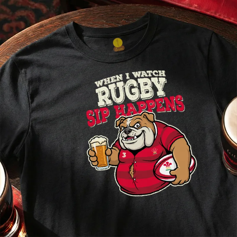 Black t-shirt with rugby-themed graphic and text  saying 'When I watch Rugby, Sip happens' on a wooden bar table