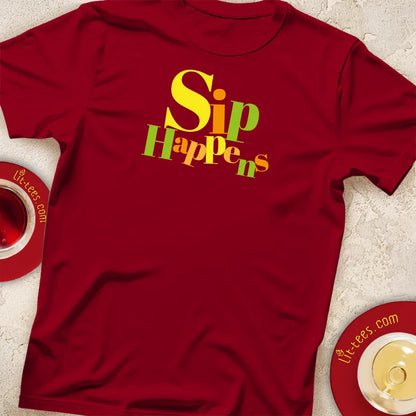 Red t-shirt with 'Sip Happens' text on a textured surface with teacups.