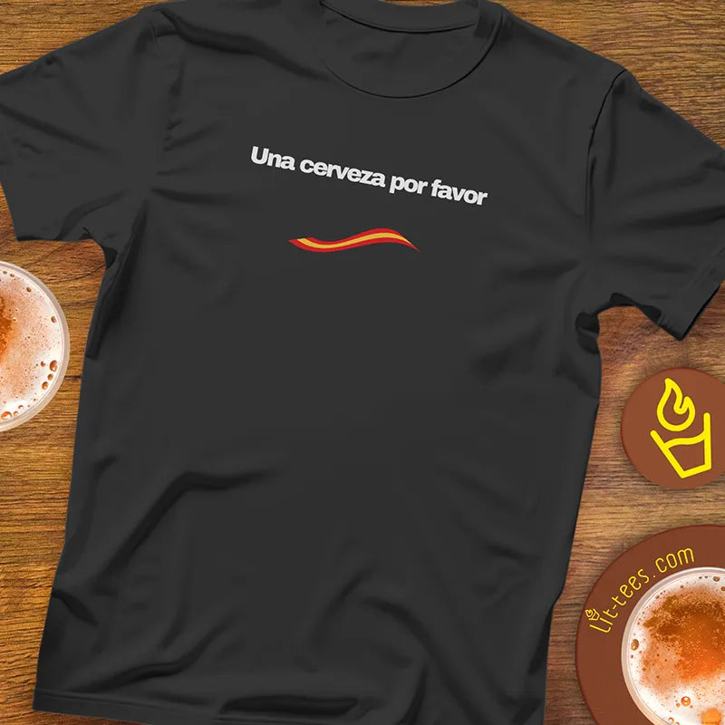 Black t-shirt with 'Una cerveza por favor' text on a wooden surface with drinks.