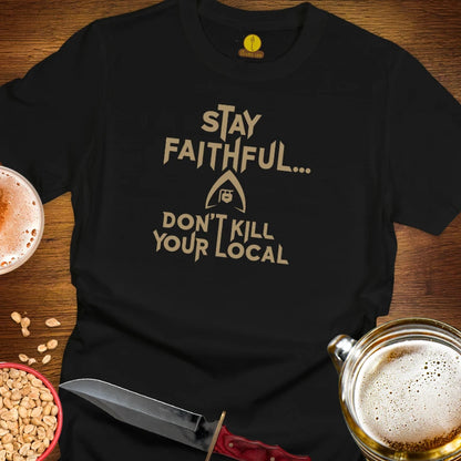 A black graphic t-shirt laid flat on a wooden surface, featuring the text 'STAY FAITHFUL.