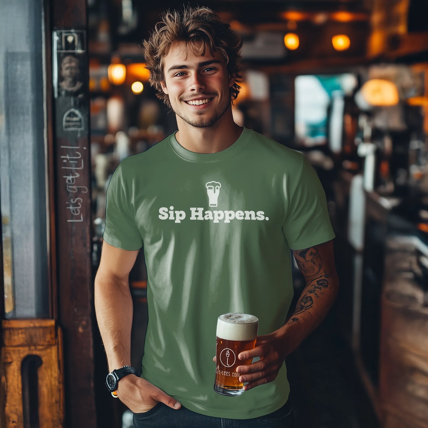 Man wearing a Military green t-shirt with 'Sip Happens.' holding a beer in a bar setting