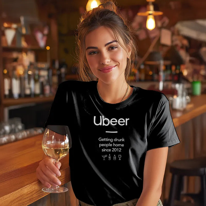 Woman in a bar wearing a black t-shirt with 'Ubeer' text, holding a glass of wine.