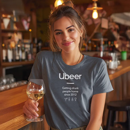 Woman in a bar wearing a t-shirt with 'Ubeer' text, holding a glass of wine.