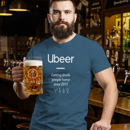 Man wearing a blue t-shirt with 'Ubeer' design, holding a beer in a bar setting.