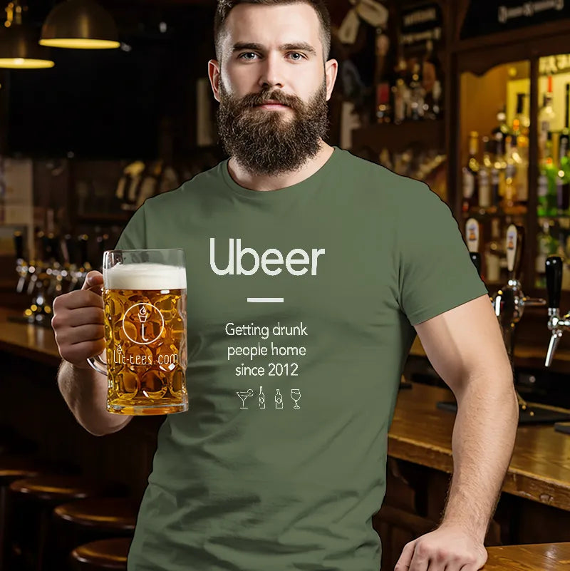 Man in a bar wearing a green t-shirt with 'Ubeer' text, holding a beer mug.
